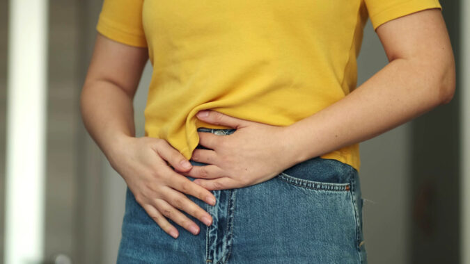 Woman touching his stomach. Stomach pain and others stomach disease concept.Girl having a stomachache. Young woman suffering from abdominal pain. Woman Stomach Ache. gastroparesis